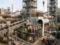Engineers welding steel frameworks during an active brownfield cement plant expansion.